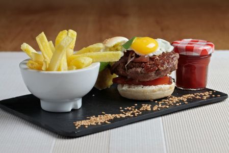 Mini hamburguesa de vaca retinta con queso idiazabal, cebolla caramelizada al vino tinto y huevo de codorniz.