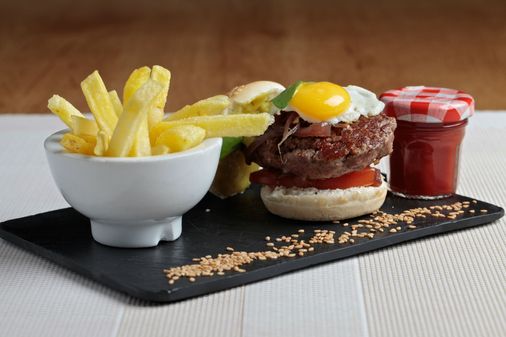 Mini hamburguesa de vaca retinta con queso idiazabal, cebolla caramelizada al vino tinto y huevo de codorniz.