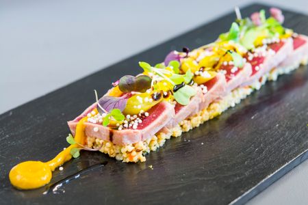 Tataki de atún con cous cous, chutney de mango y piparras