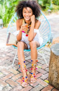 Perfekte Kombi: Ein weißes Sommerkleid und bunte Pom Pom Sandalen