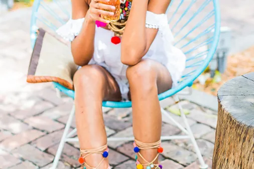 Perfekte Kombi: Ein weißes Sommerkleid und bunte Pom Pom Sandalen
