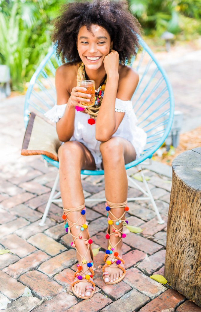 Perfekte Kombi: Ein weißes Sommerkleid und bunte Pom Pom Sandalen