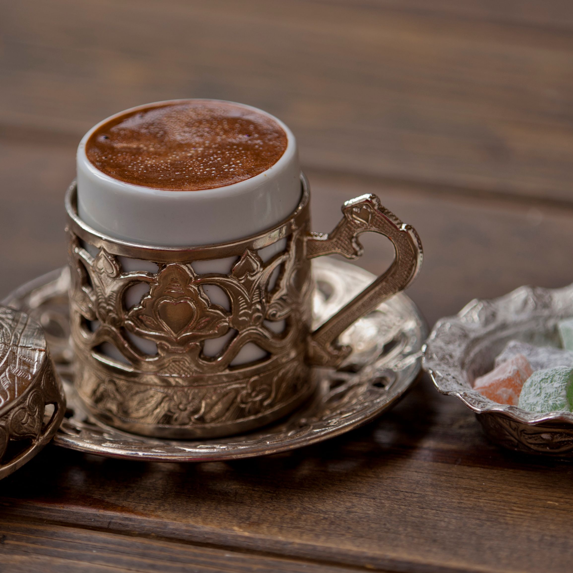 Taza de café con leche en forma de corazón, granos de café en la