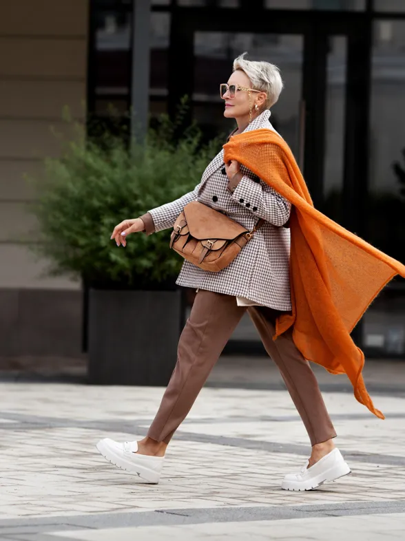 Skechers arrasa con los zapatos sin cordones, cómodos y modernos para llevar con pantalón beige y camisa blanca a los 60